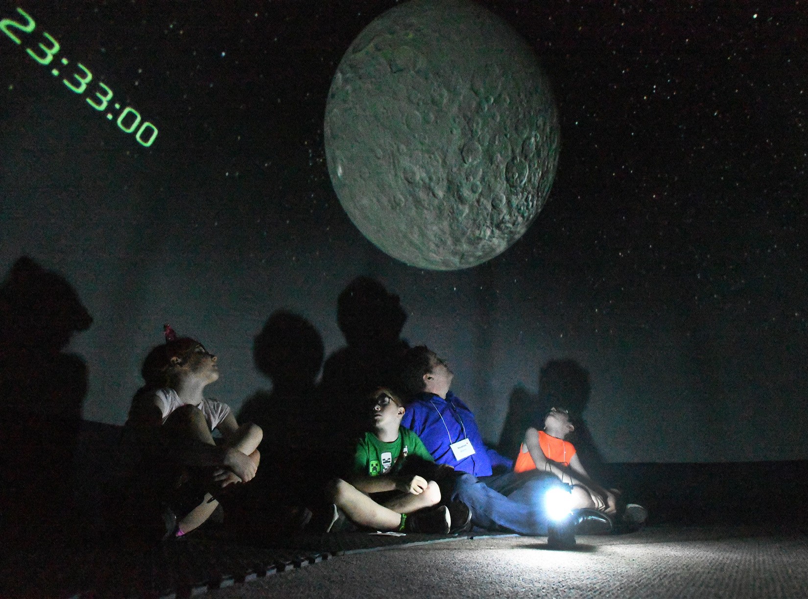 Children seated on the floor in an inflatable planetarium