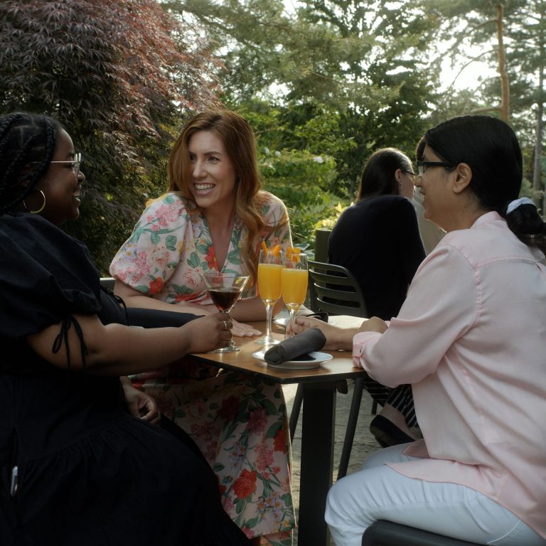 guests laughing and enjoying drinks on the patio of the Rock Garden Bistro