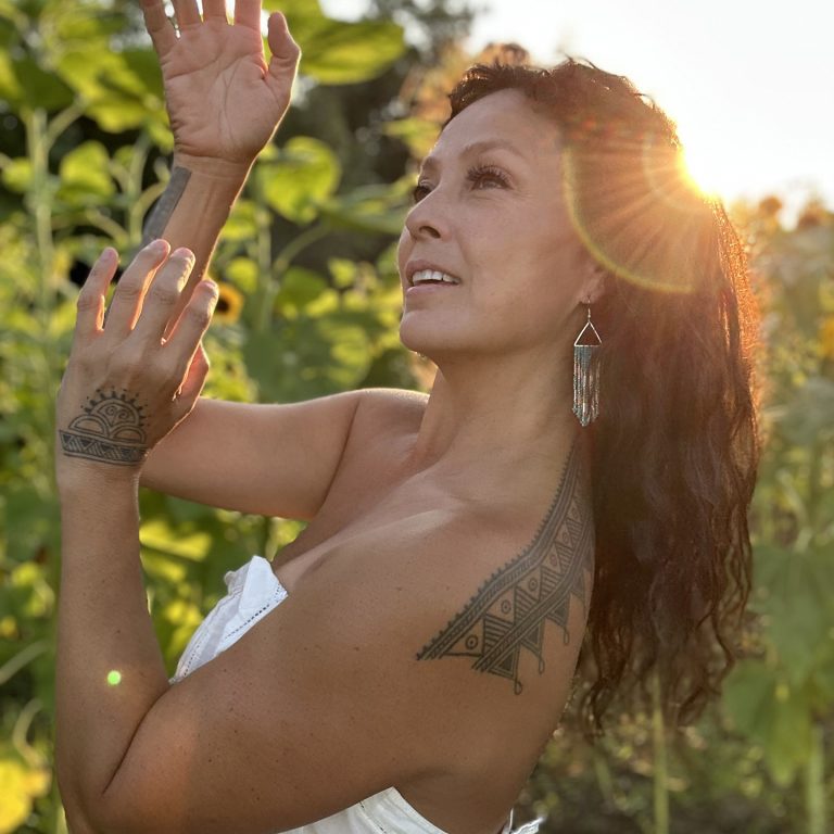 Santee smith dancing in a natural space at golden hour