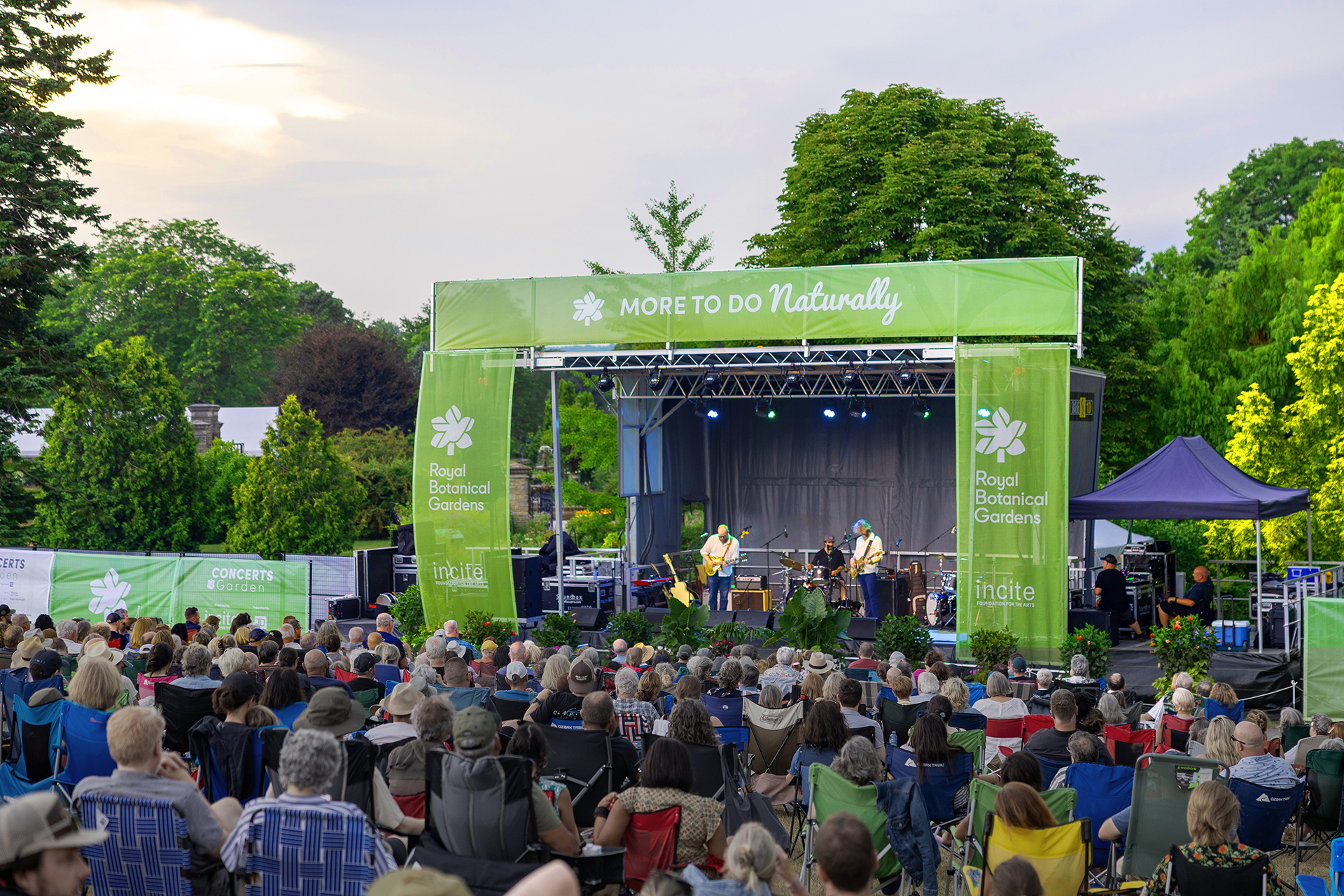 Outdoor concert in the gardens on an open stage decorated with plants