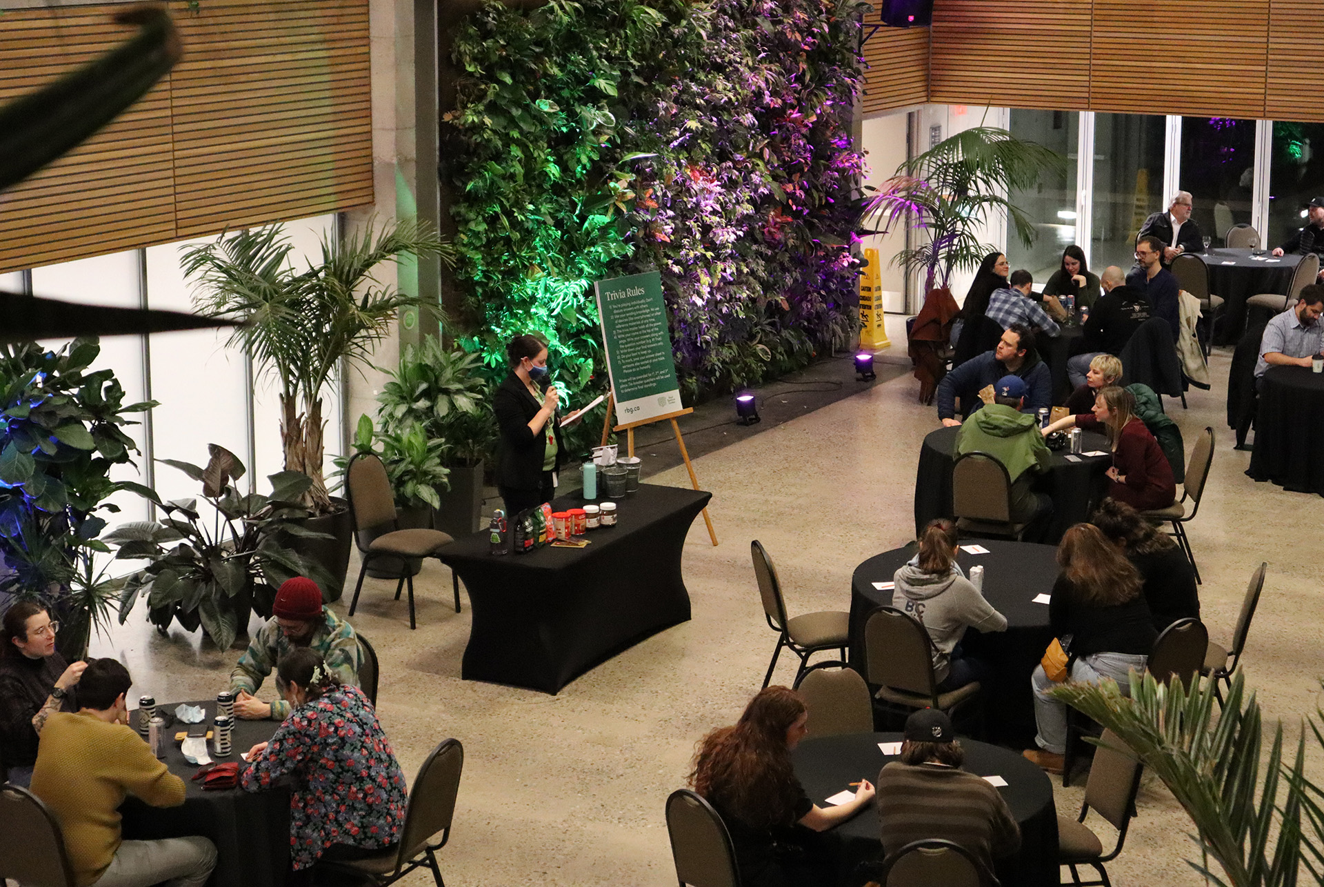 Groups seating at small tables in the atrium participating in pub trivia