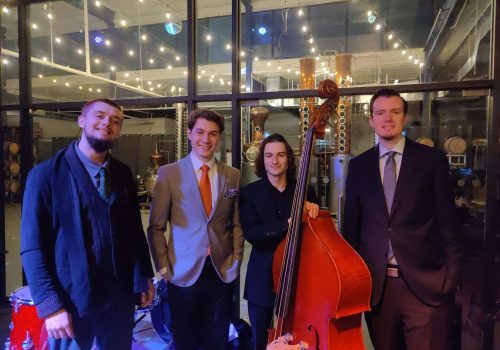 received_1099947480679529 Quartet of musicians dressed in suits and semi formal attire, one holding upright bass