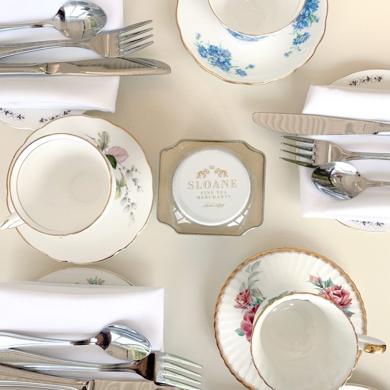 looking down at a set tea table with a tin of tea in the centre